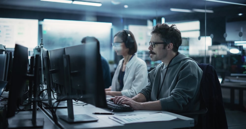 Cybersecurity Pros at Desk Computers Blue