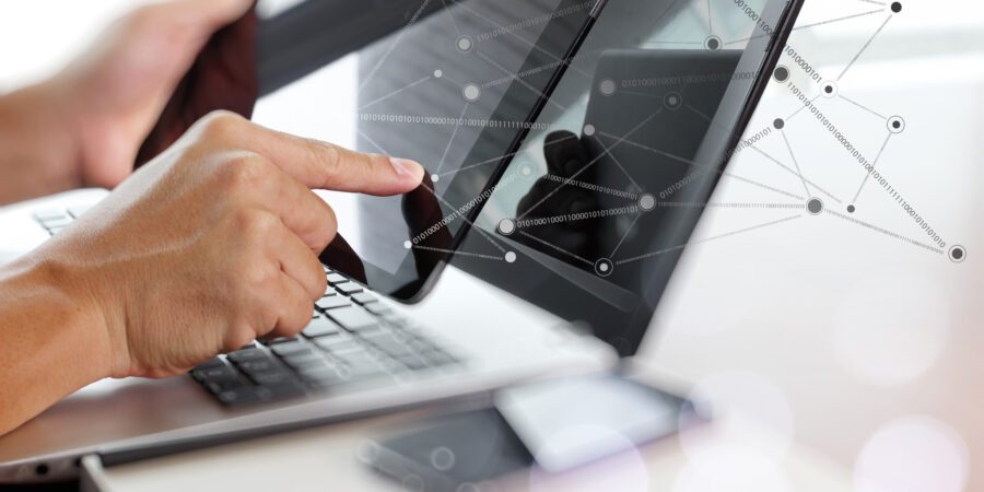 Man holding tablet with laptop on desk & illustration of virtual connections.