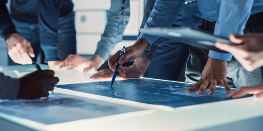 people sharing ideas and working on a project on the desk